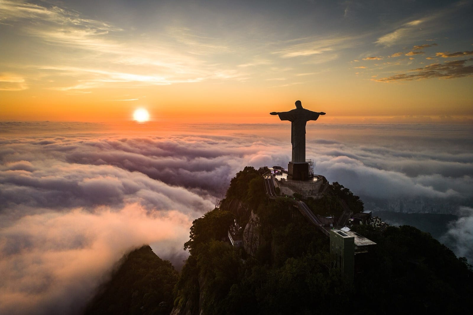 Christ the Redeemer on the peak of Corcovado at sunrise, above a sea of cloud