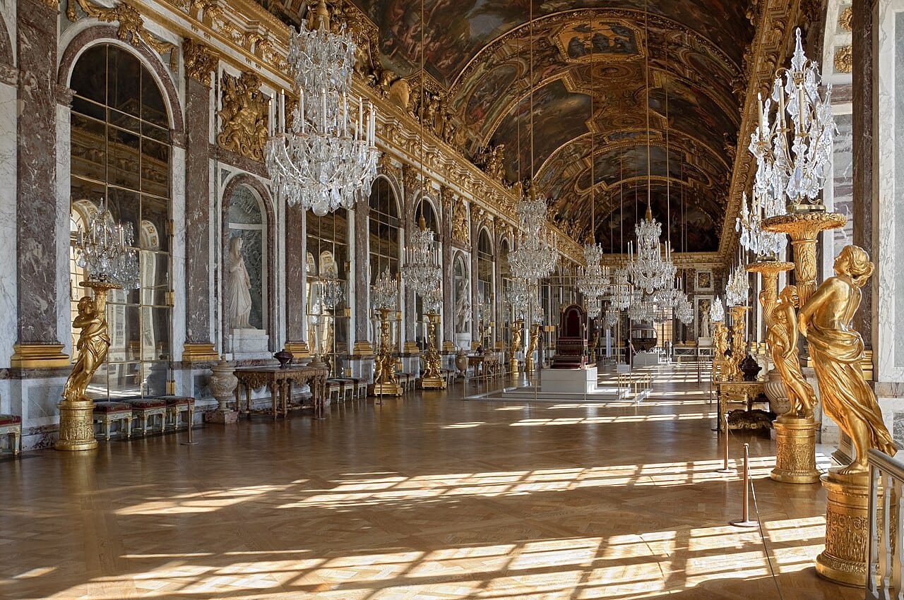 The chandeliers, painted ceiling and mirrored arches of the Hall of Mirrors at Versailles