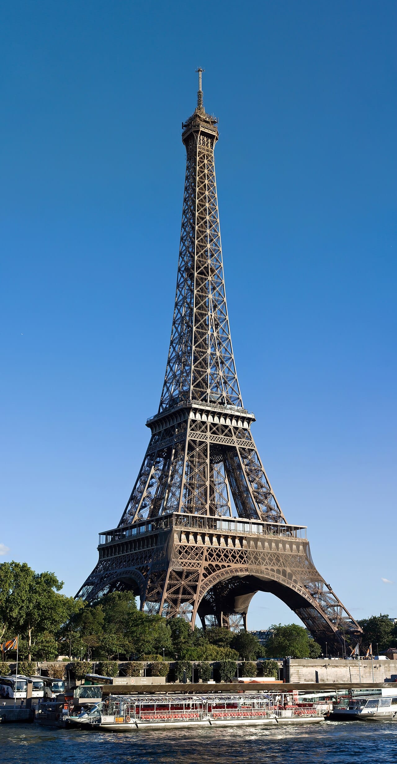 The Eiffel Tower rising above the trees, seen from Avenue de New York across the Seine