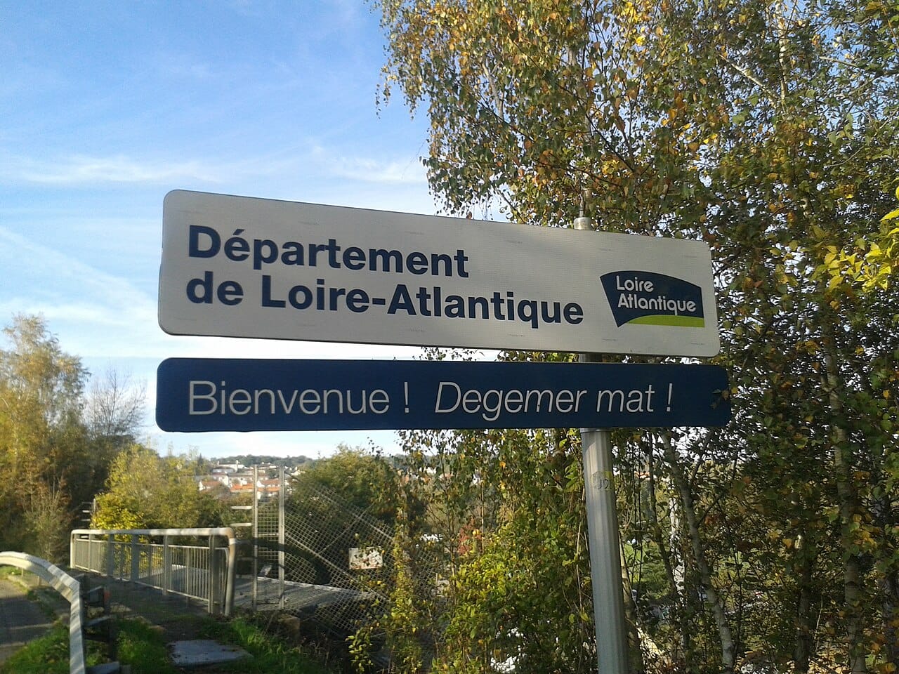A roadside place-name sign written in both French and Breton near Oudon