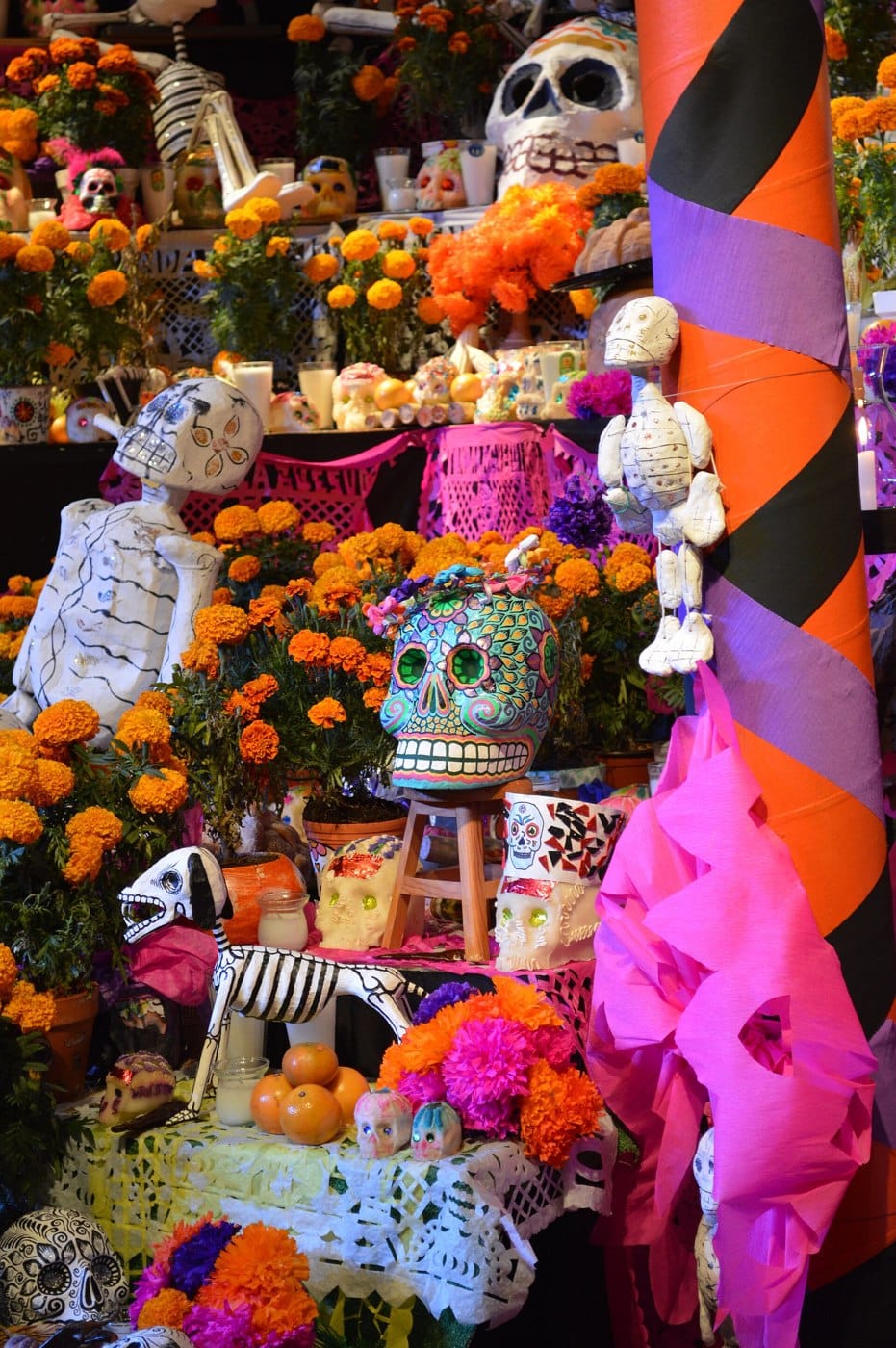 Marigolds, paper decorations and skeleton figures on a Día de Muertos altar