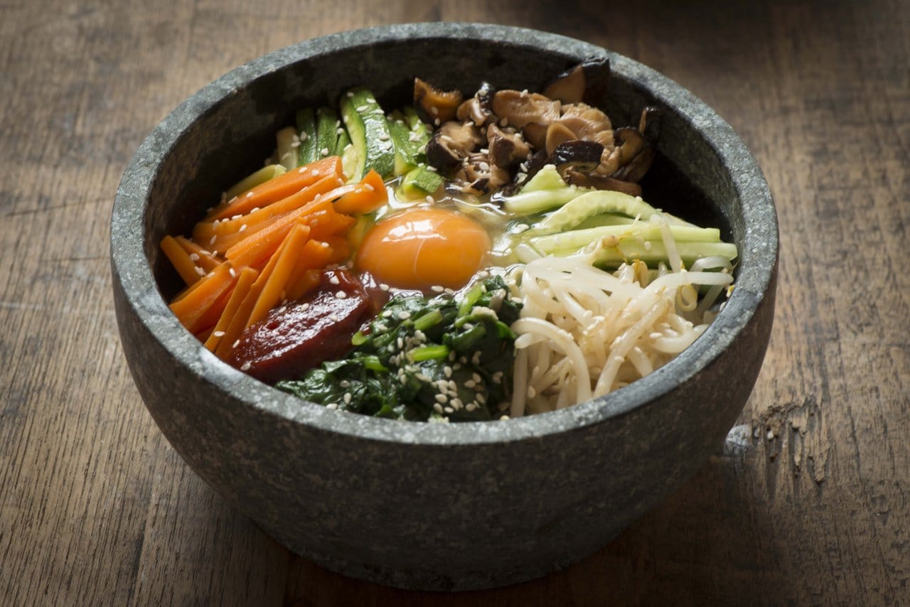 Bibimbap with vegetables and egg served in a hot stone bowl