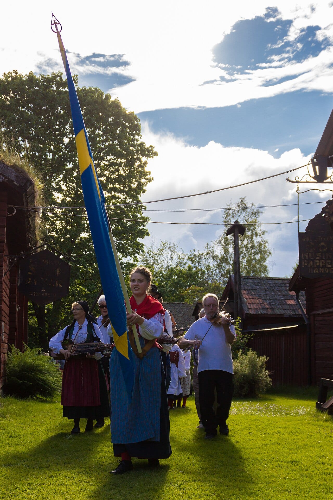 A Swedish midsummer procession carrying flowers to the maypole