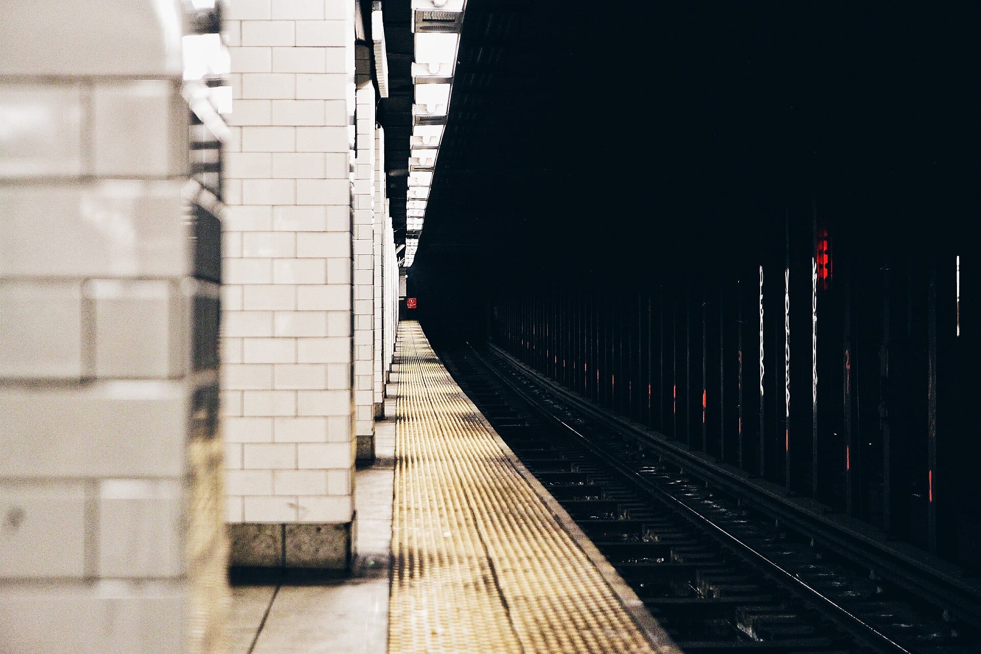 The tiled edge of an underground platform running off into the tunnel