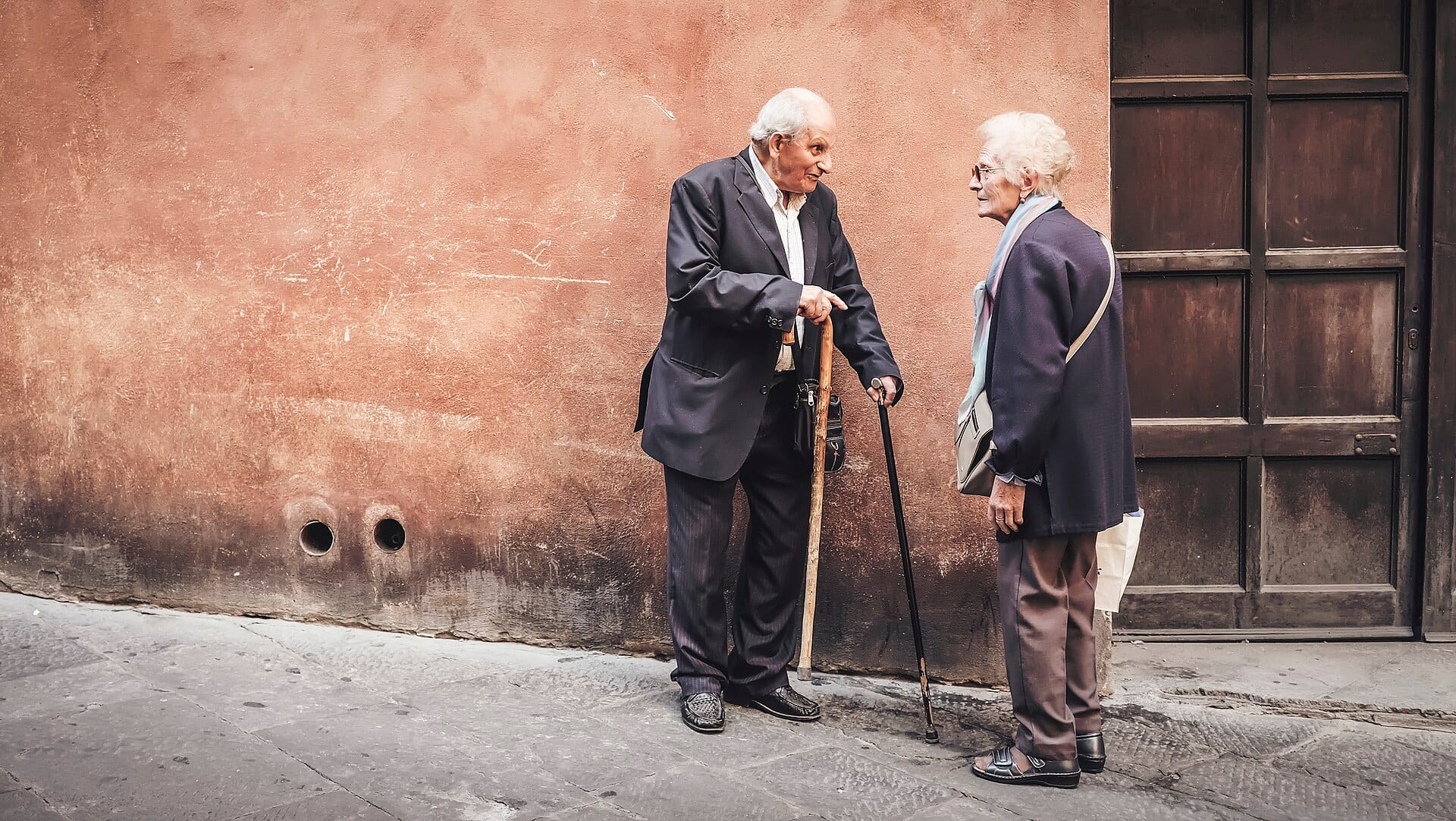Two older people stopped for a conversation on the street