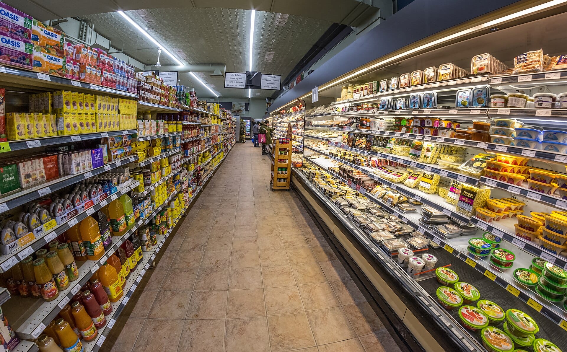 A supermarket aisle between stacked shelves and a chilled cabinet
