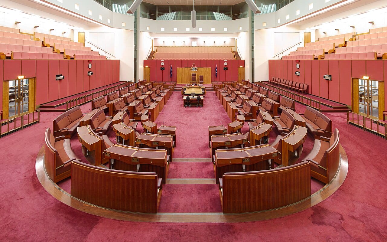 The empty benches of a debating chamber, seen from the floor