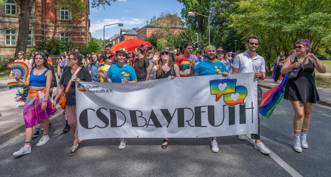 A march filling a street behind a banner