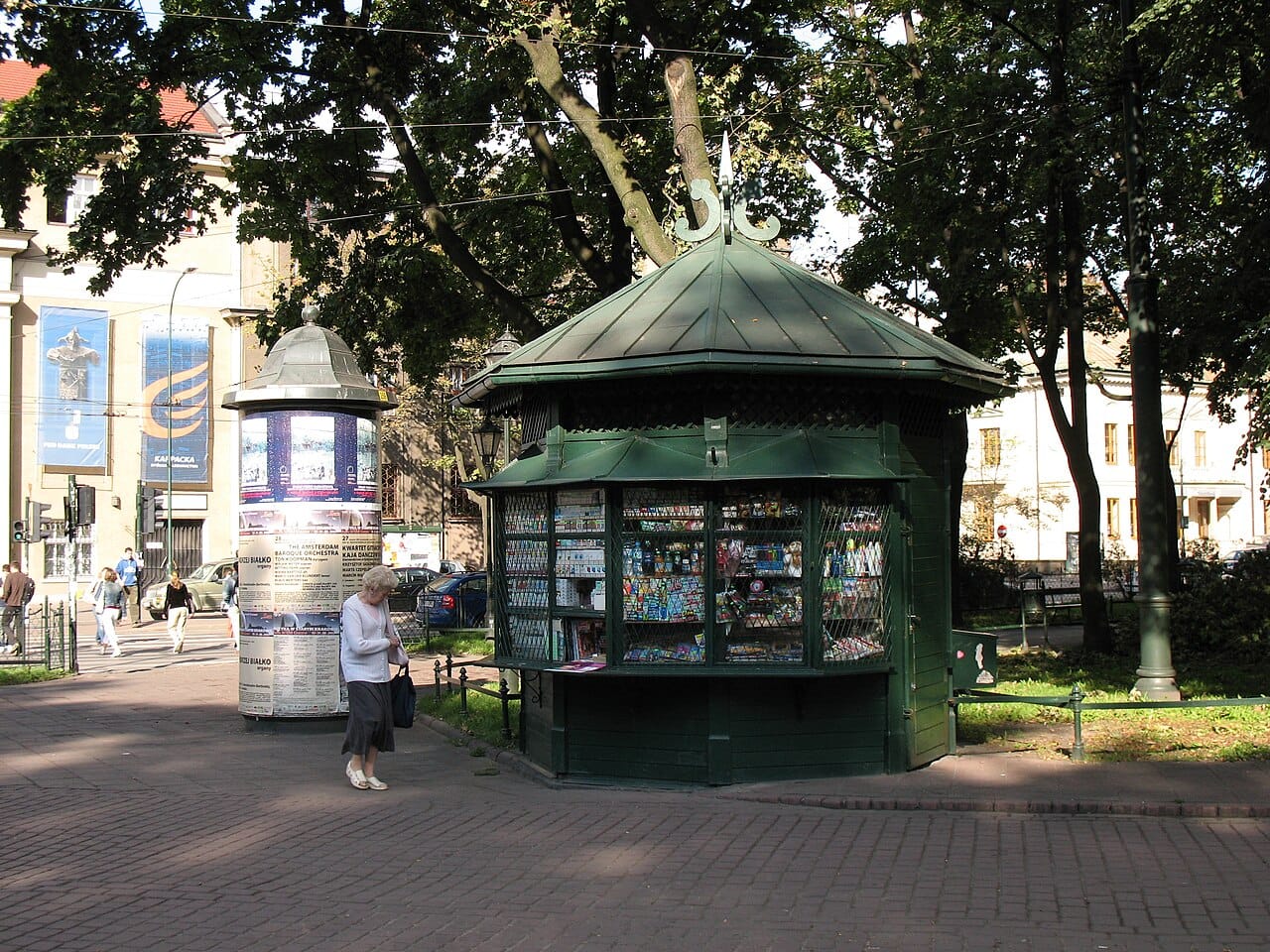A newspaper kiosk on a city street, the day’s papers racked outside