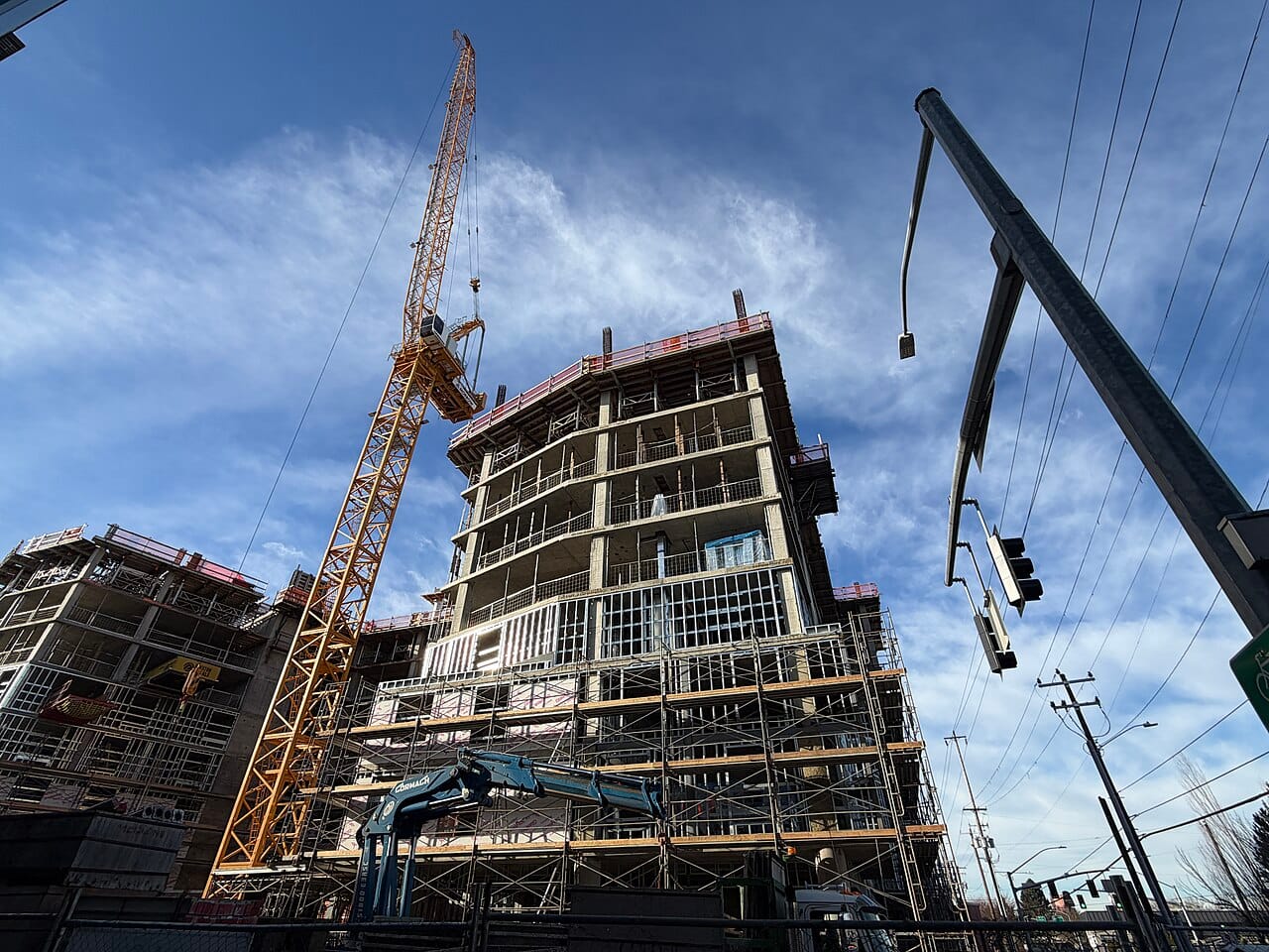 A tower crane over a building going up in a city