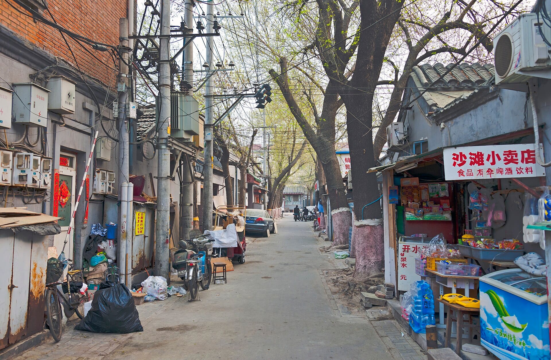 A corner shop in Yinzha Hutong, Beijing, its red sign offering food, umbrellas, beer and drinks