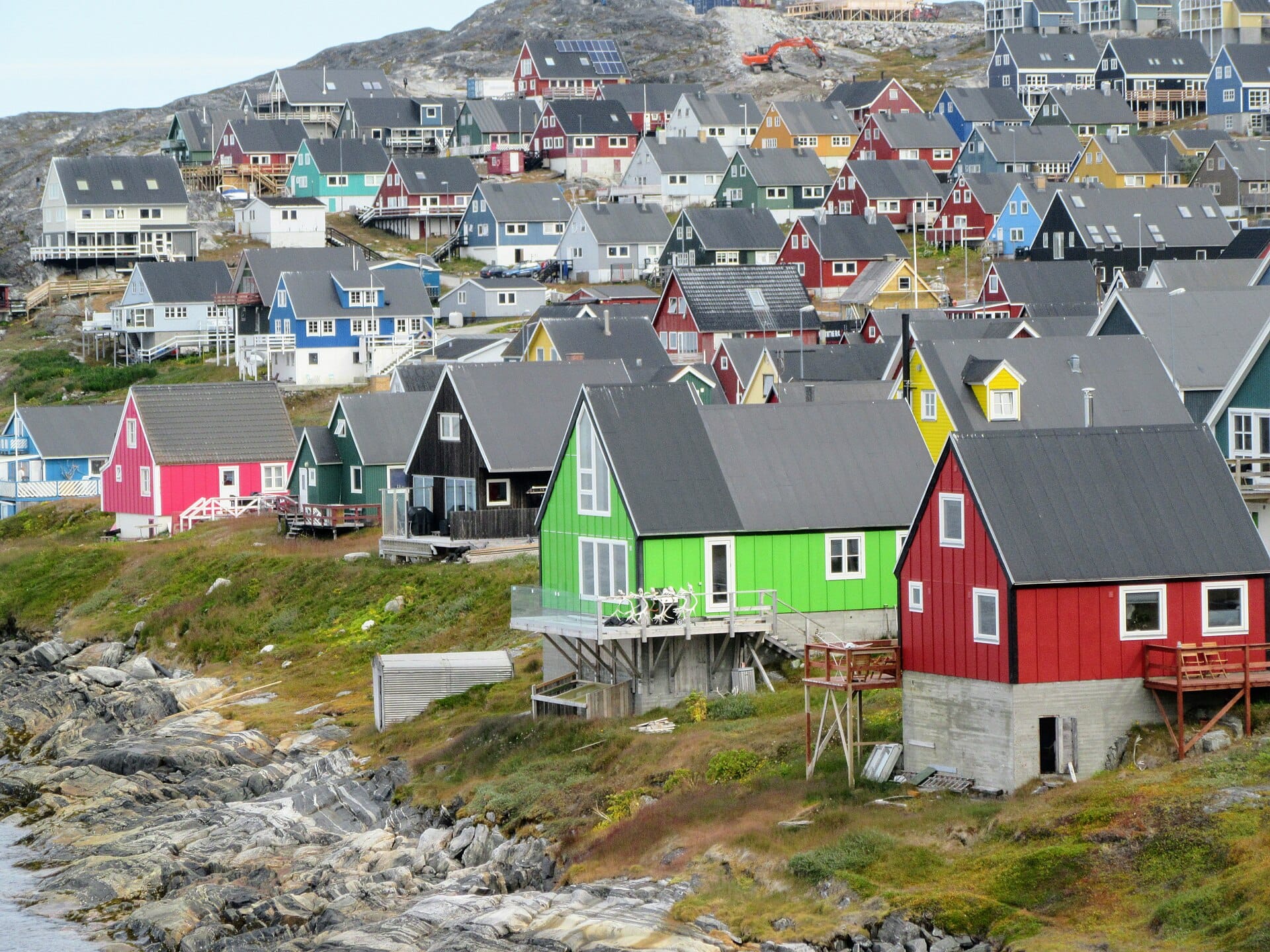 The painted timber houses of Nuuk stacked along the shore