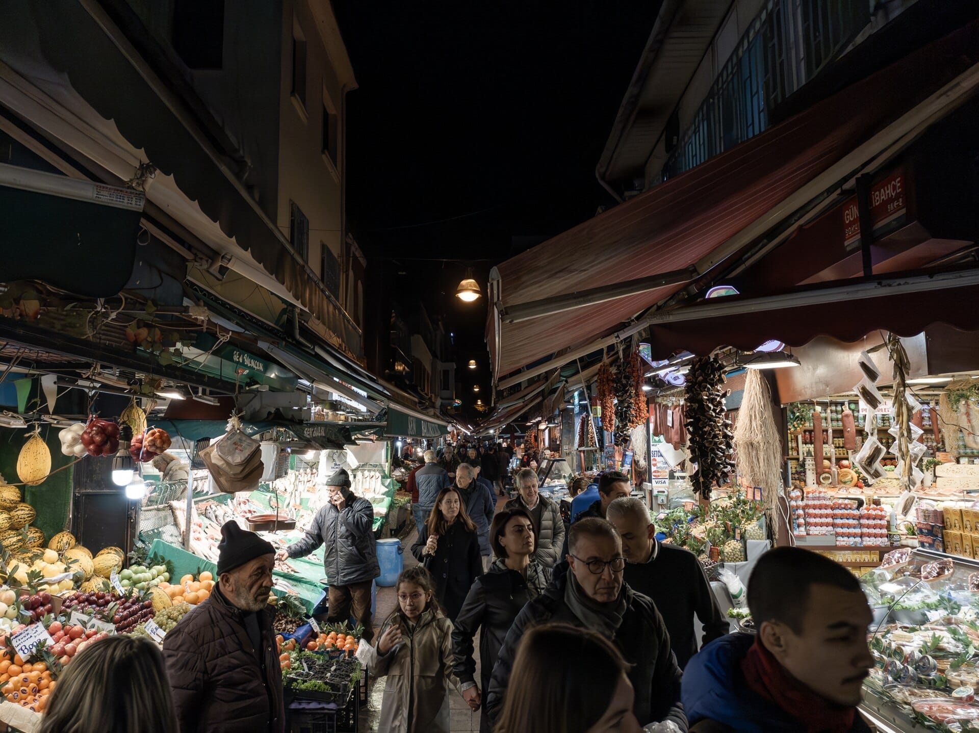 The fruit and fish stalls of the Kadikoy market in Istanbul, lit under their awnings after dark