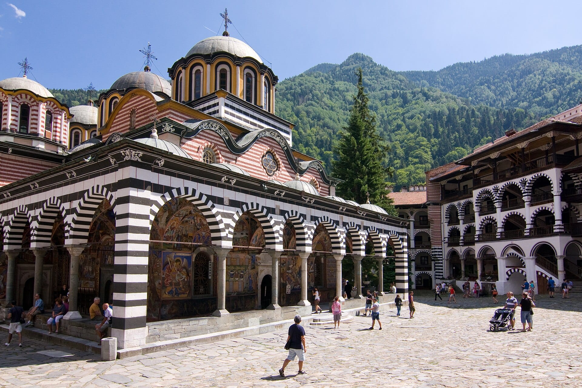 The frescoed arcades and striped stonework of Rila Monastery