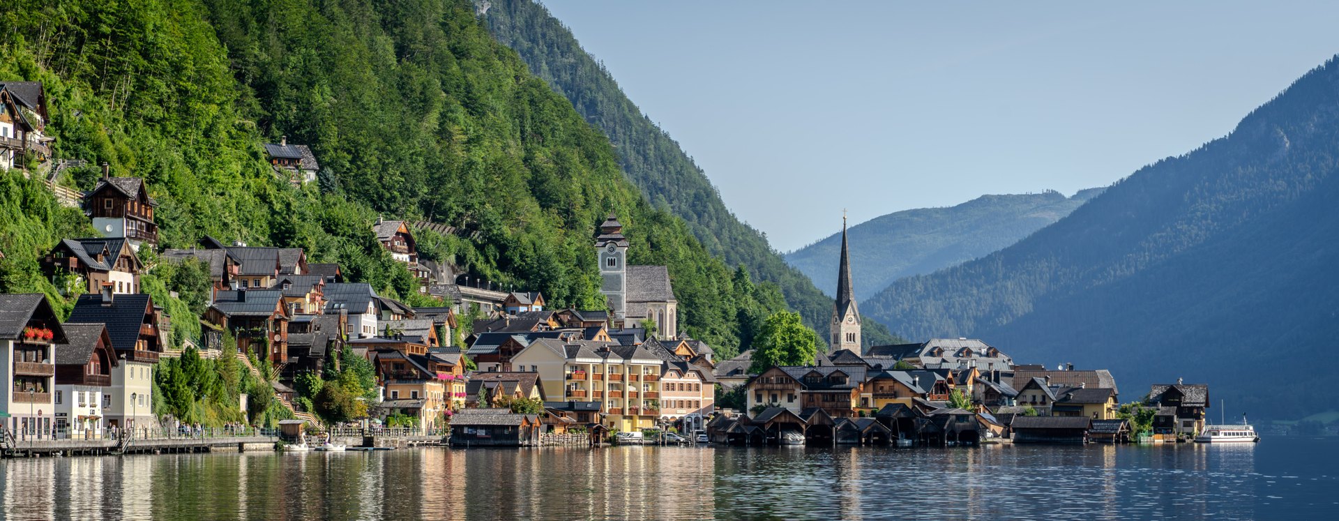 Hallstattโs waterfront and churches beneath the mountains beside Hallstรคtter See