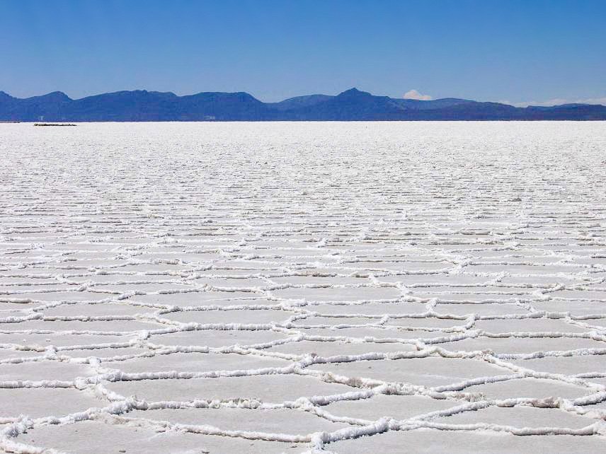 A broad white salt crust beneath a blue sky at Salar de Uyuni in Bolivia