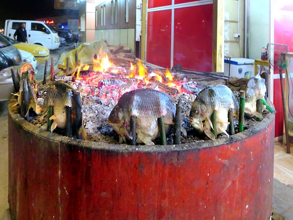 Masgouf fish cooking beside a fire in Basra, Iraq