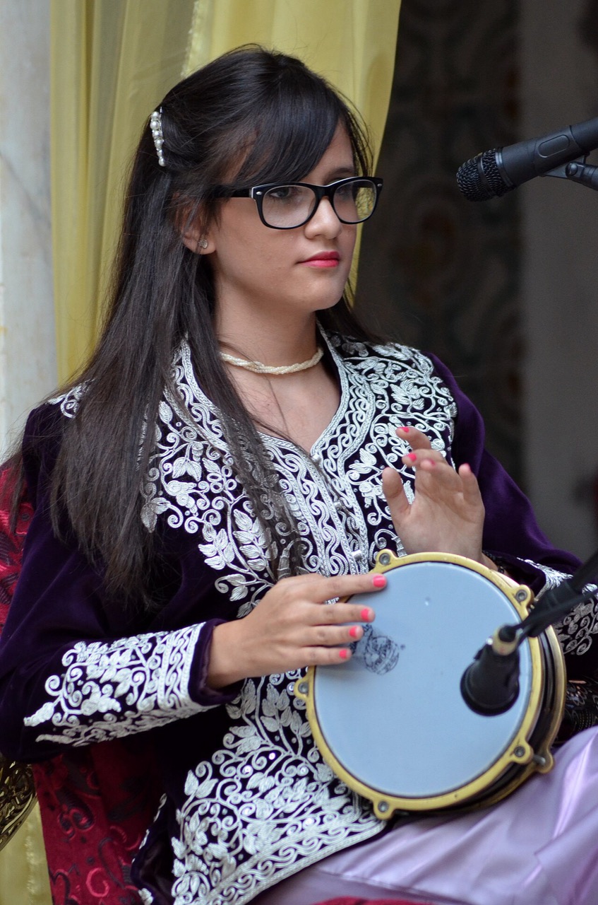 A musician in traditional dress playing a darbuka, Algeria