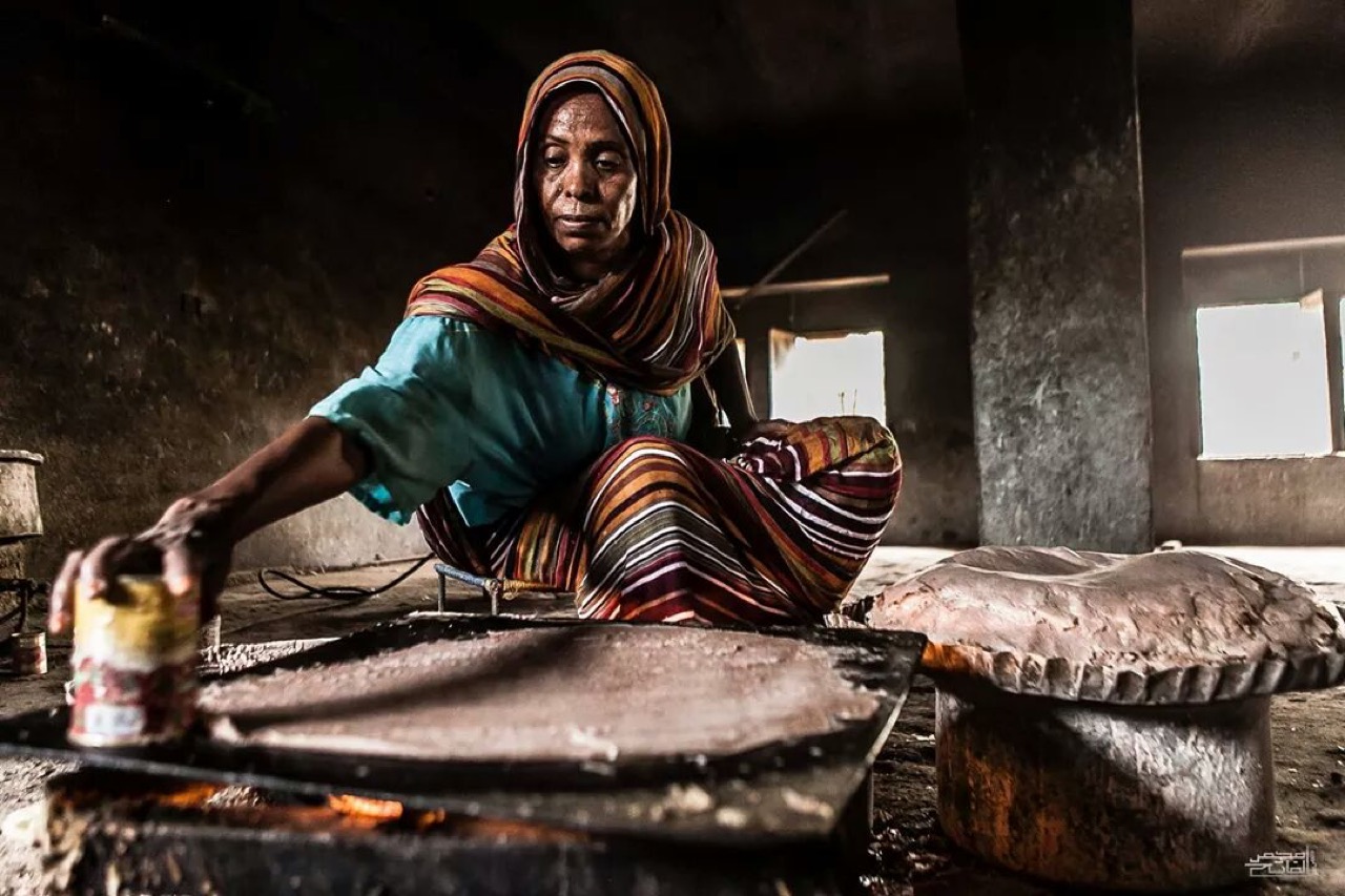A woman preparing kisra, Sudan