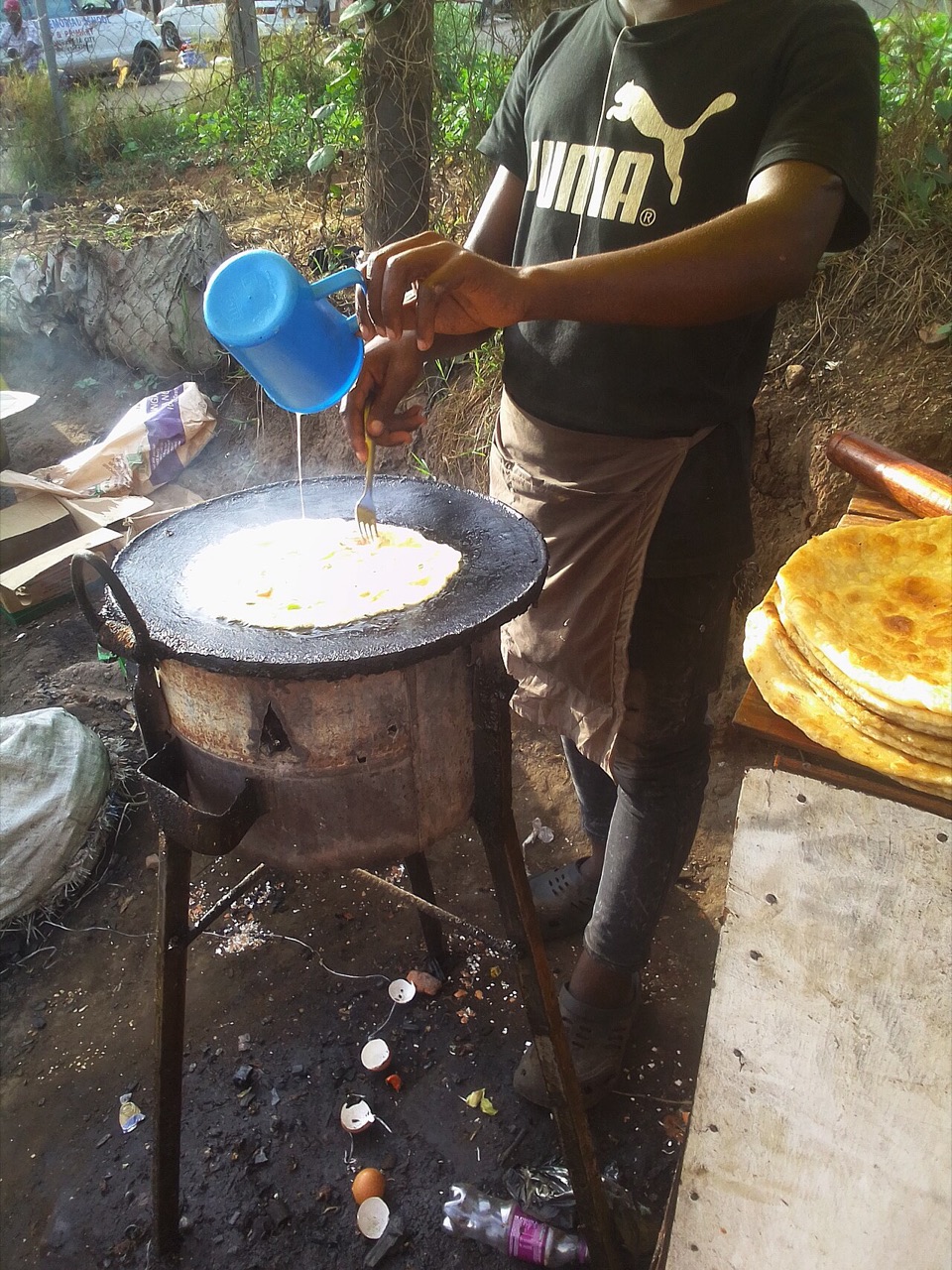 Preparing a rolex egg-and-chapati wrap in Mbarara, Uganda