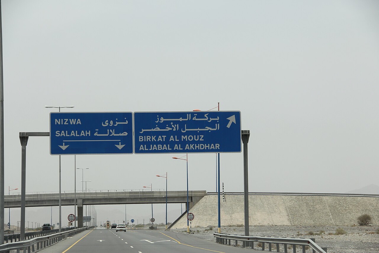 Arabic and English lettering on a road sign in Oman