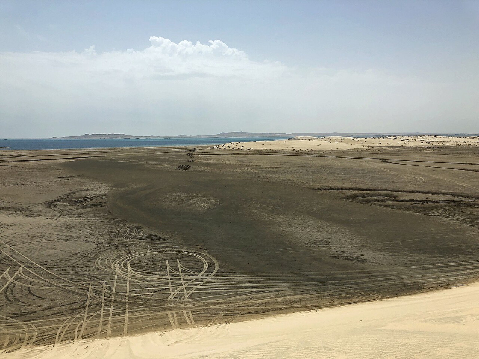 Sand dunes meeting the inland sea at Khor Al Adaid in Qatar