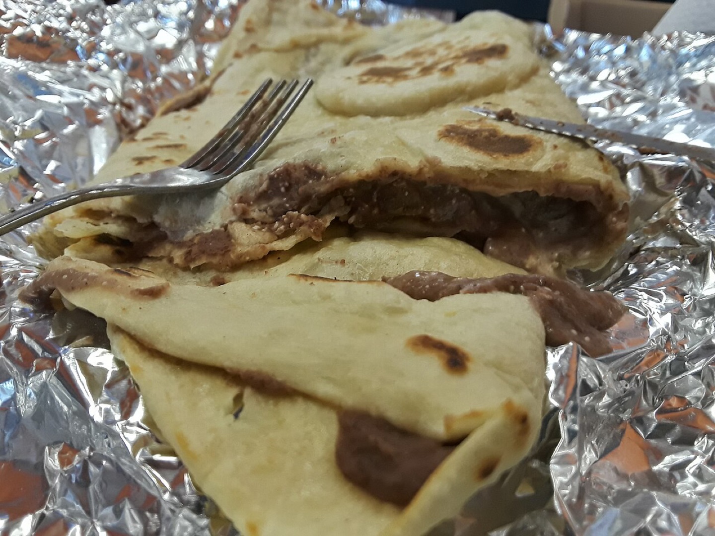 A baleada filled with beans, cheese and meat