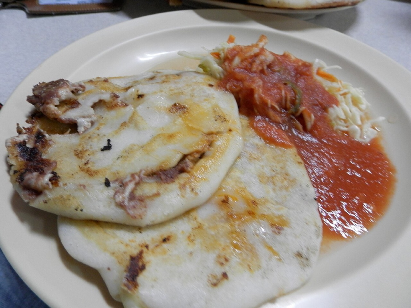 Pupusas served with curtido and salsa in El Salvador