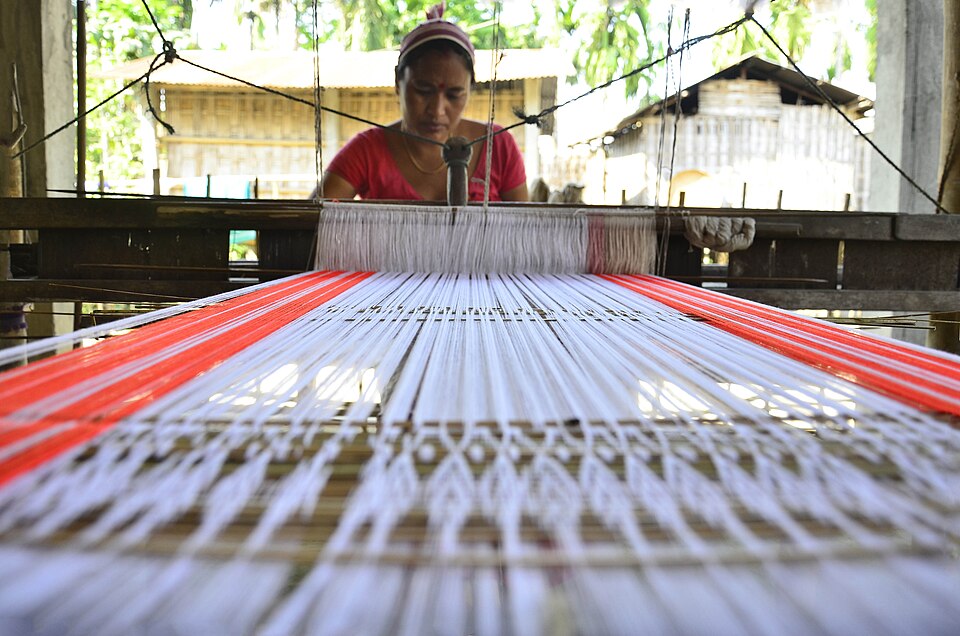 A woman weaving at a loom on Majuli island in Assam
