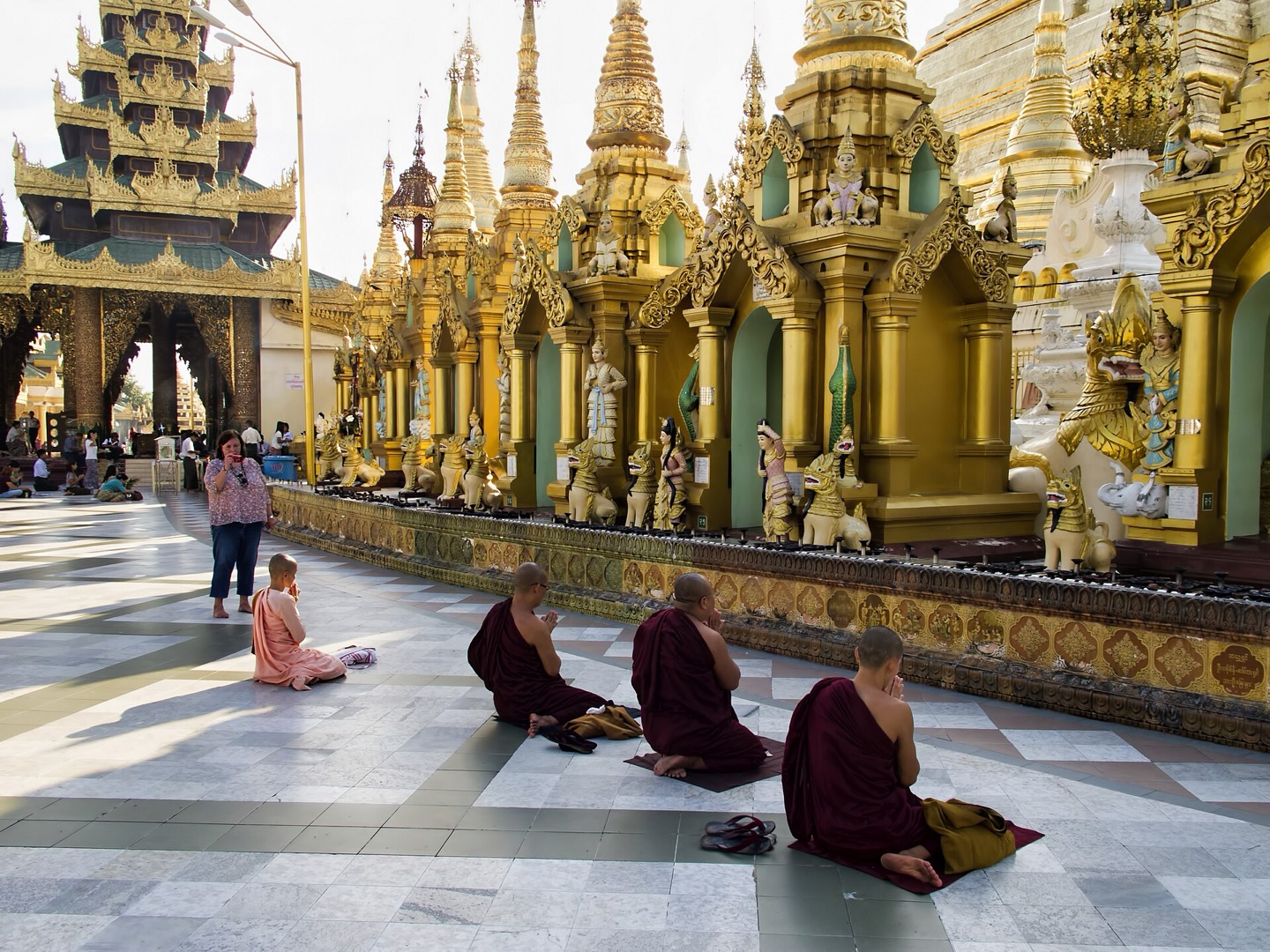 A nun and monks praying at Shwedagon Pagoda in Yangon, Myanmar