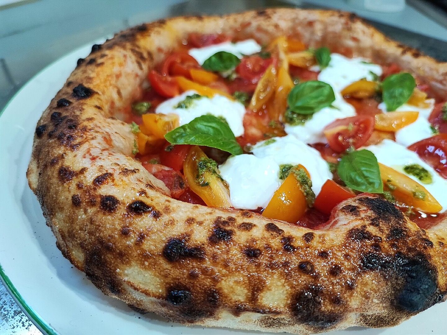 A Neapolitan pizza with a blistered crust, fresh mozzarella and basil