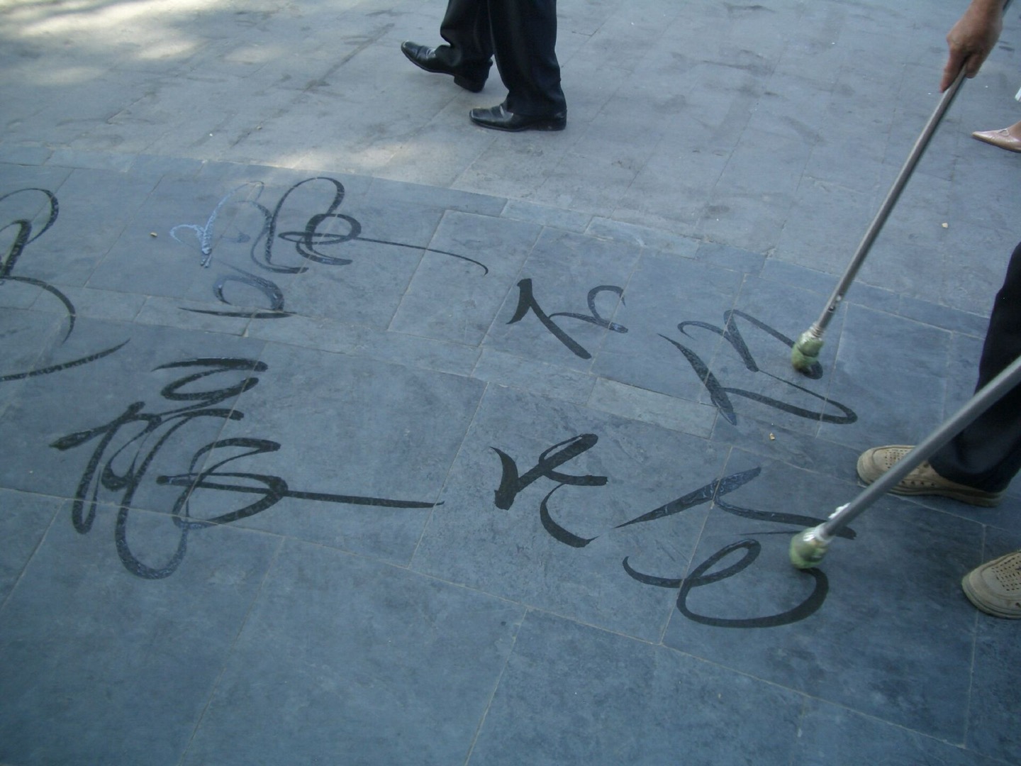 A man writing characters in water on paving at the Summer Palace in Beijing
