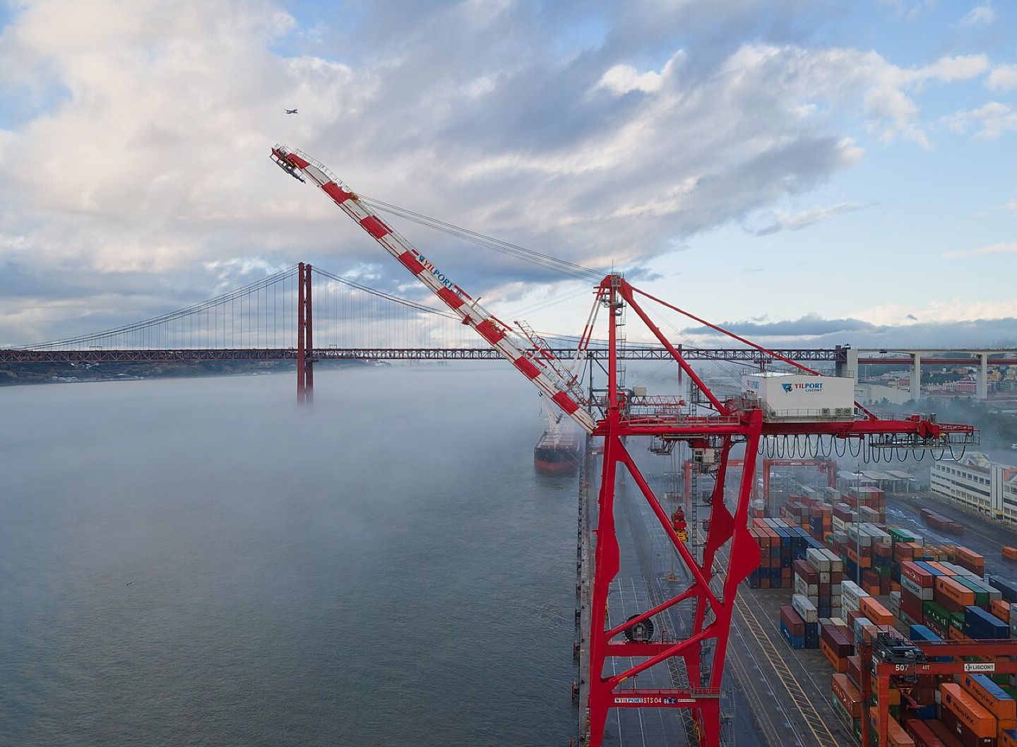 Container cranes at the Alcântara docks in Lisbon with the 25 de Abril bridge behind them