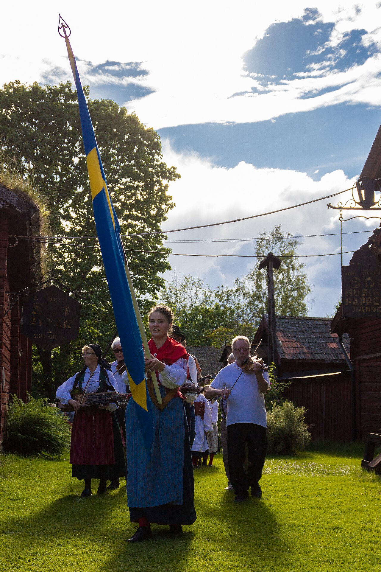 A Swedish midsummer procession carrying flowers to the maypole