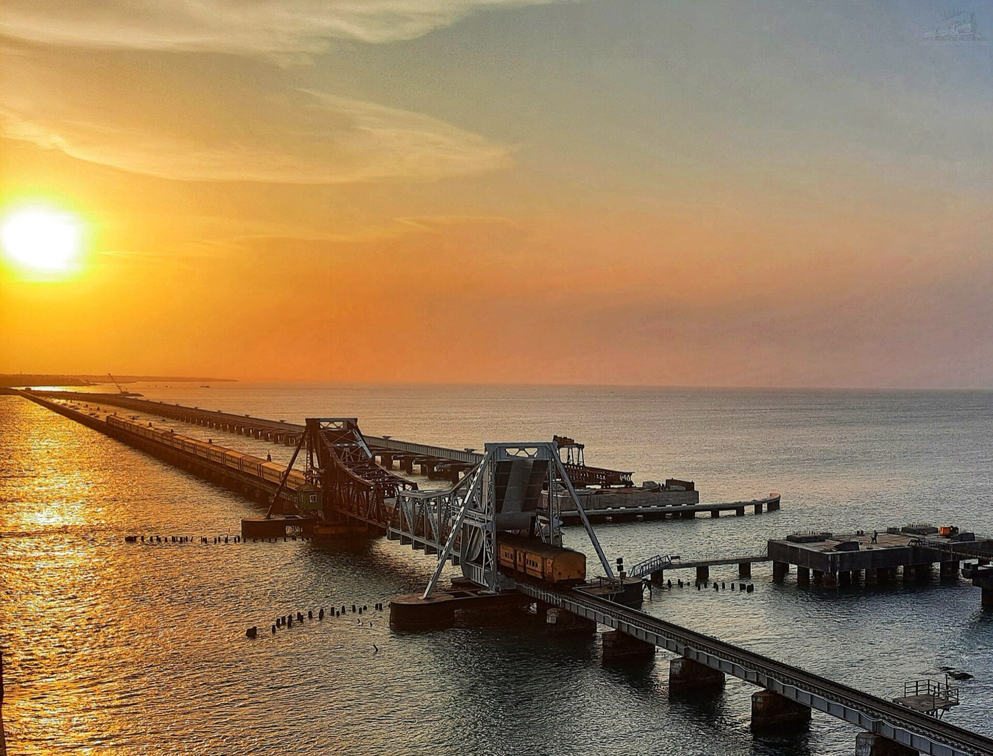 A train crossing Pamban Bridge at sunset in Tamil Nadu, India