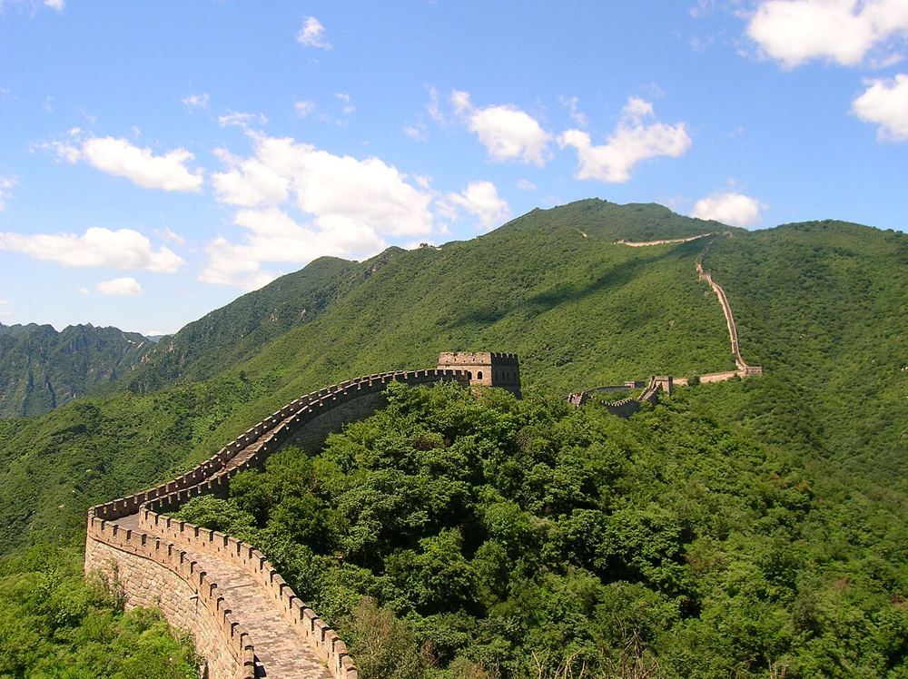 The Great Wall climbing a green ridge at Mutianyu