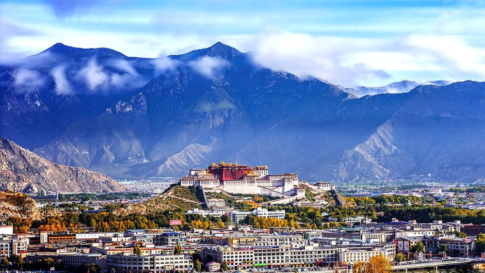The white and red Potala Palace on its hill above Lhasa, mountains behind