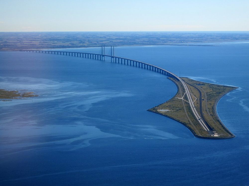 The Øresund Bridge running across the sea onto the long, narrow island of Peberholm, where the road drops into the tunnel