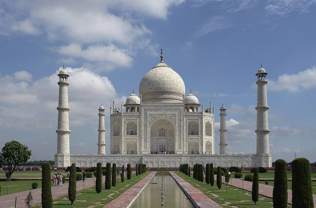 The white marble Taj Mahal behind its long reflecting pool and rows of cypress trees