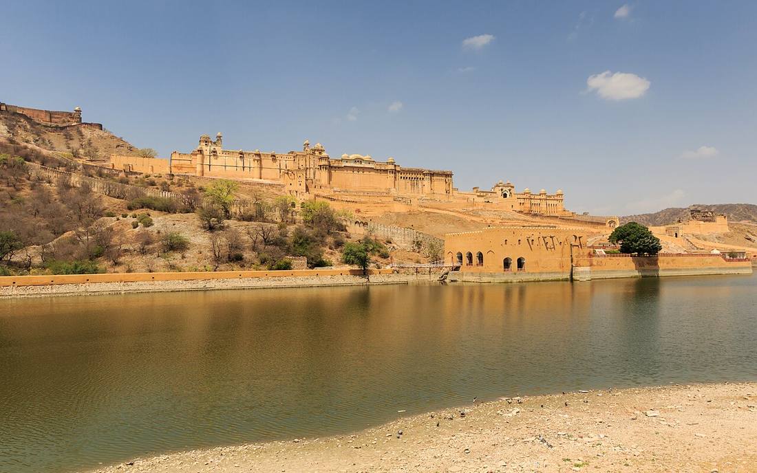 Amber Fort stretched along a dry hillside above the still water of Maota Lake