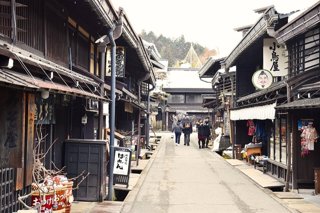 A narrow street of dark wooden merchant houses in old Takayama