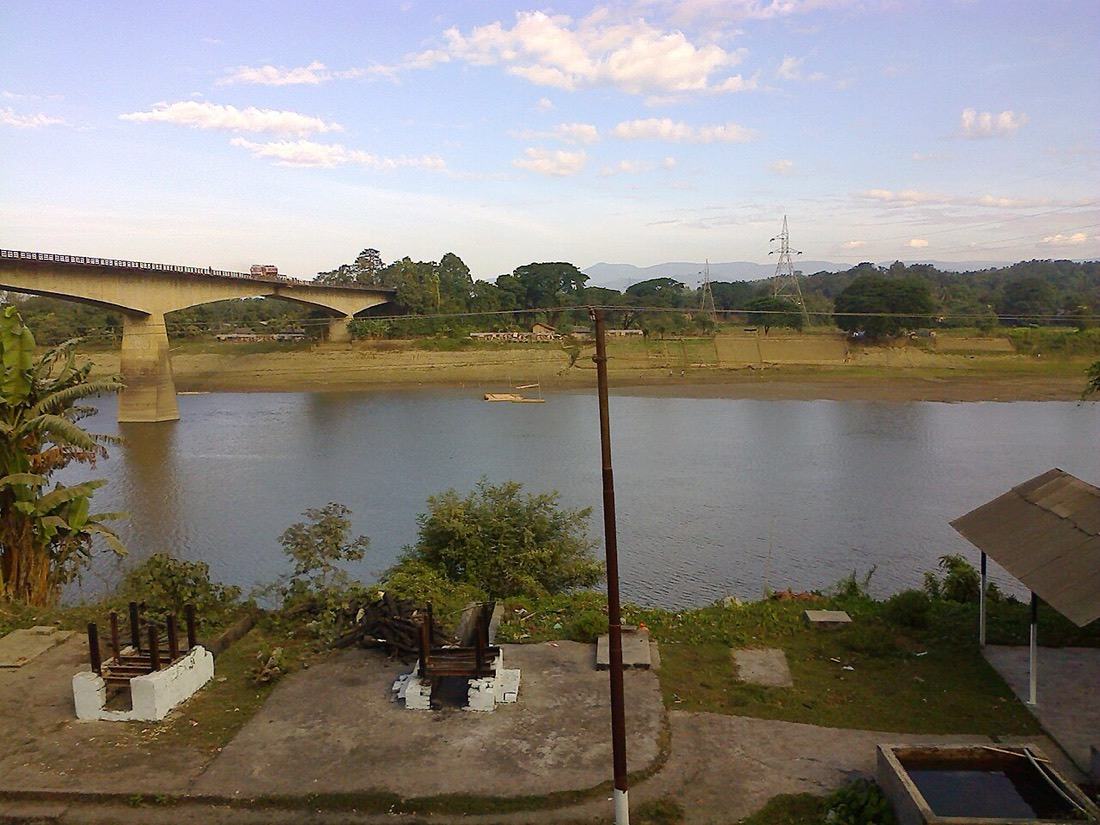 The wide Barak River at Lakhipur, with a road bridge in the distance