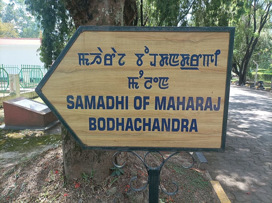 A wooden signboard in Imphal with Meitei Mayek above the English words Samadhi of Maharaj Bodhachandra