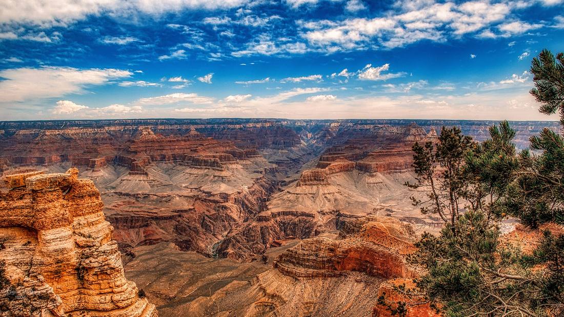 Red and orange layers of rock falling away into the Grand Canyon from the South Rim
